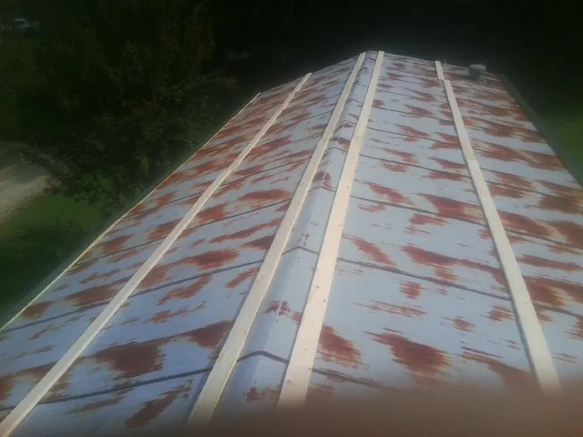 Rusted metal roof panels with new wood purlins before replacement — Storm Damage Roof Repair in Happy Jack by Roofing Brothers