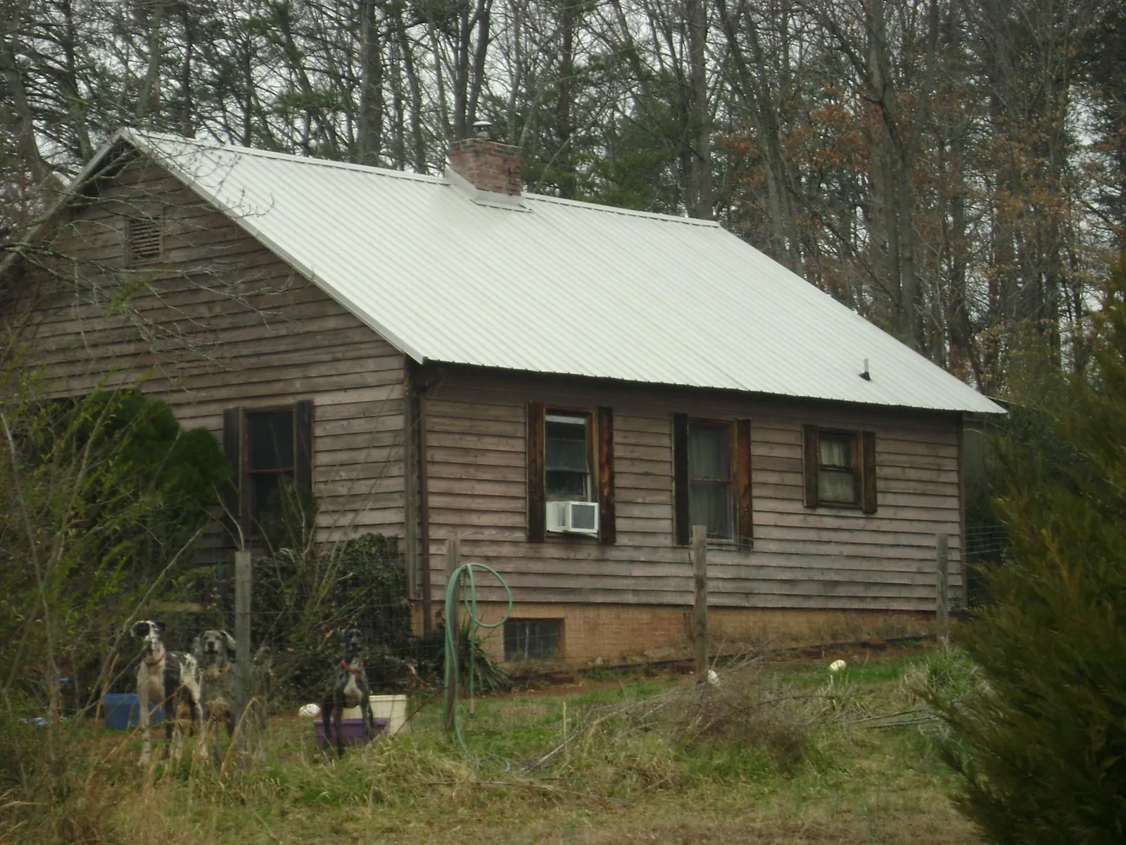 White metal roof on an old wood sided farmhouse, from a Metal Roof Installation job in Happy Jack